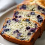 Close-up of sliced blueberry zucchini bread on a modern ceramic plate