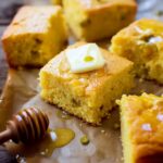 Close-up of Hatch Chile Cornbread slice topped with butter and honey