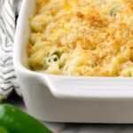 Baked Hatch Chile Mac and Cheese in white casserole dish with crispy topping