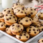 Mini chocolate chip muffins stacked on a white plate