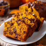 Sliced chocolate chip pumpkin bread on a white plate with melty chips