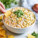 Corn dip recipe served with tortilla chips in a white bowl