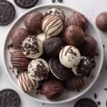 Oreo Balls coated in white, milk, and dark chocolate on a serving plate